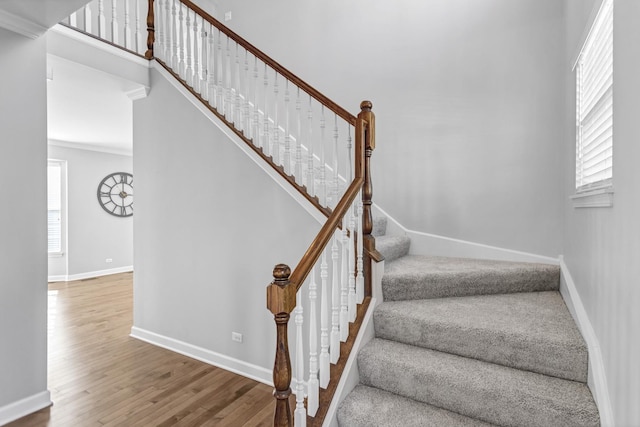 stairs featuring plenty of natural light, wood finished floors, and baseboards