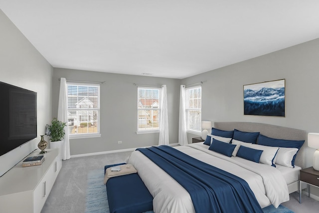 bedroom with light colored carpet and baseboards