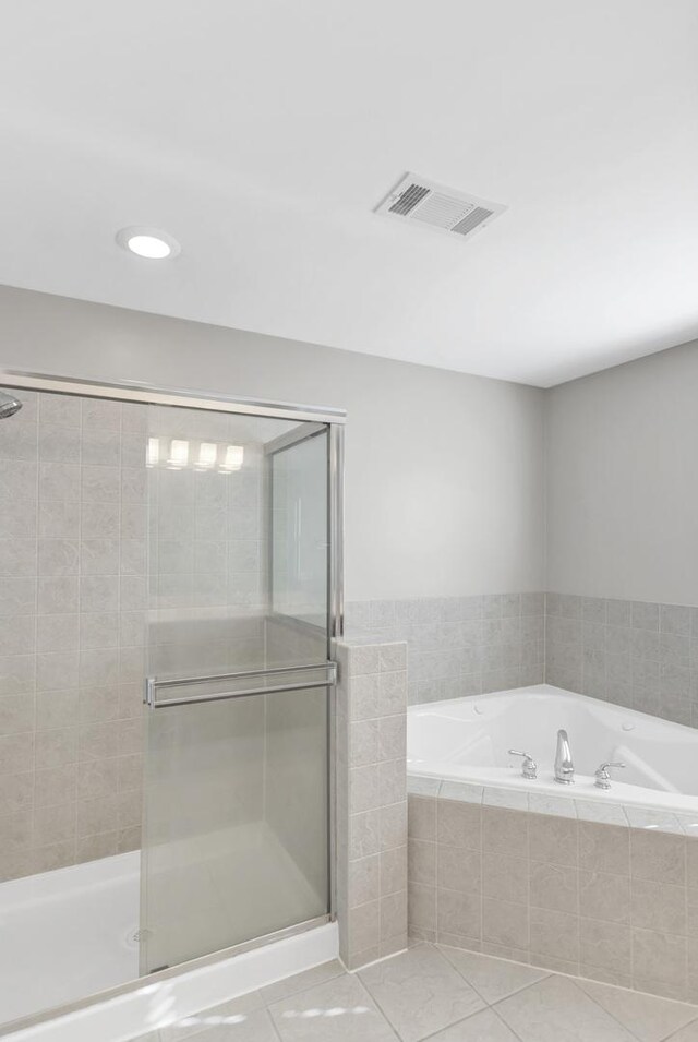 full bathroom with a garden tub, visible vents, and a shower stall