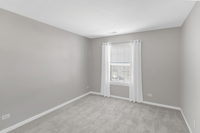 spare room with visible vents, baseboards, and carpet