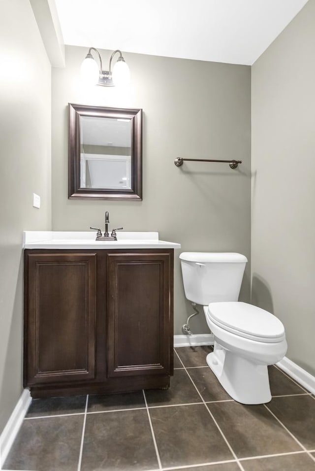 bathroom featuring tile patterned floors, baseboards, toilet, and vanity