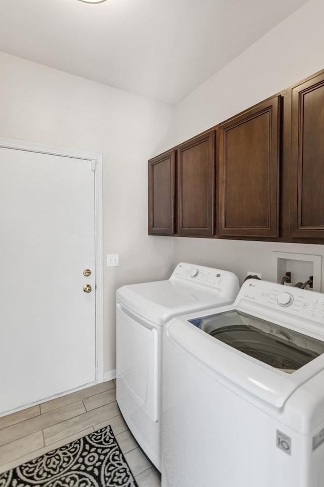 washroom featuring cabinet space, independent washer and dryer, and wood tiled floor