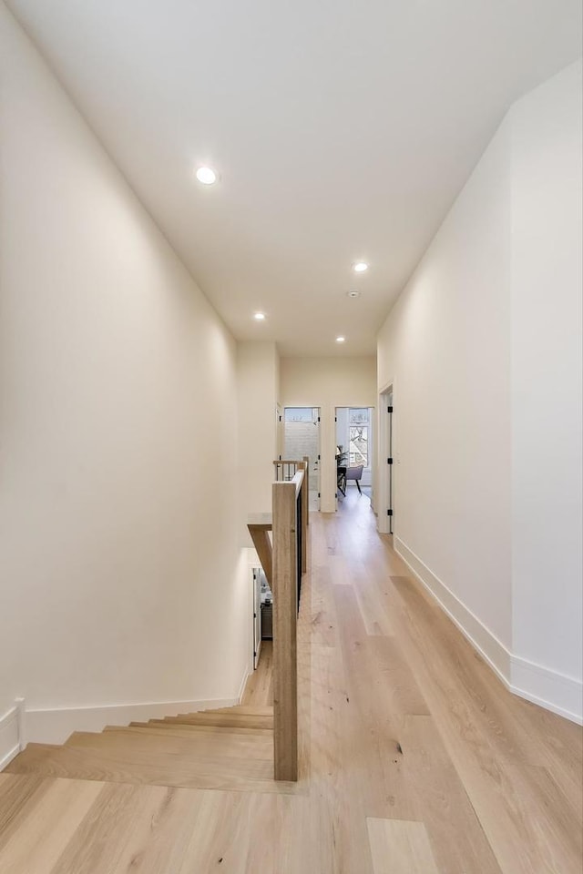 hall with recessed lighting, baseboards, an upstairs landing, and light wood-style flooring