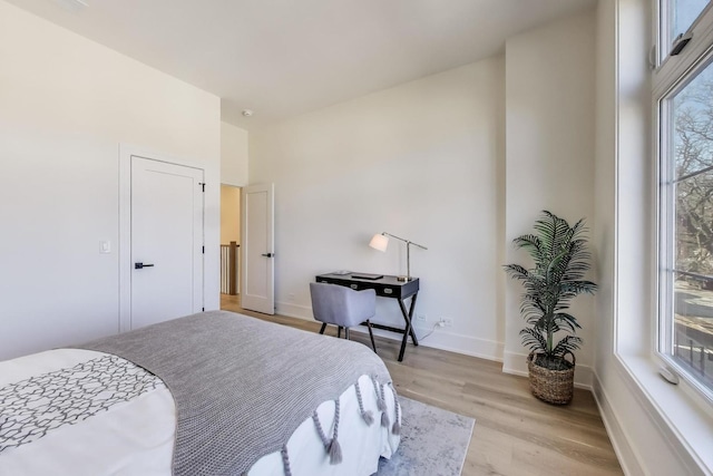 bedroom featuring baseboards and light wood finished floors