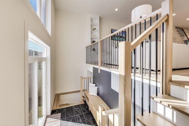 stairway featuring recessed lighting and a towering ceiling