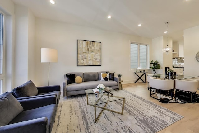 living room featuring recessed lighting, baseboards, an inviting chandelier, and wood finished floors