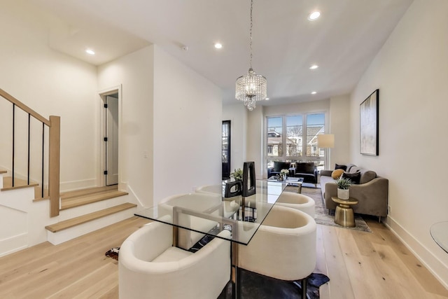 dining space featuring wood finished floors, baseboards, an inviting chandelier, recessed lighting, and stairs