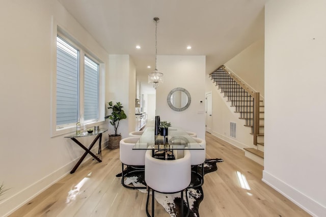 dining area with stairs, light wood-style flooring, visible vents, and baseboards