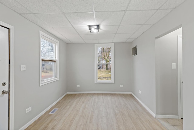 interior space featuring visible vents, plenty of natural light, and a drop ceiling