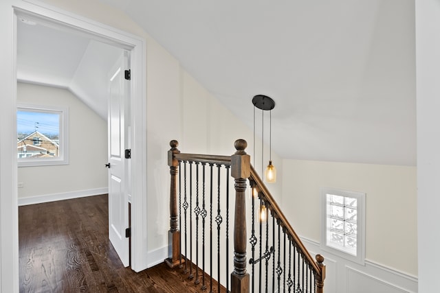 corridor with lofted ceiling, an upstairs landing, dark wood-style flooring, and baseboards