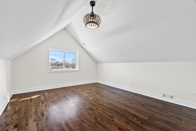 bonus room with vaulted ceiling, dark wood-style floors, visible vents, and baseboards