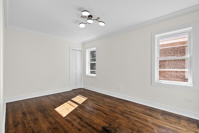 unfurnished room with baseboards, dark wood-type flooring, and crown molding