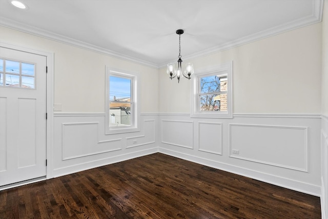 unfurnished dining area featuring a notable chandelier, plenty of natural light, ornamental molding, and dark wood-style flooring