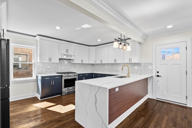 kitchen featuring a wealth of natural light, ornamental molding, high end stainless steel range oven, ventilation hood, and white cabinets