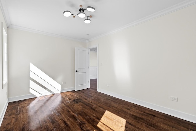 spare room with hardwood / wood-style floors, baseboards, and ornamental molding