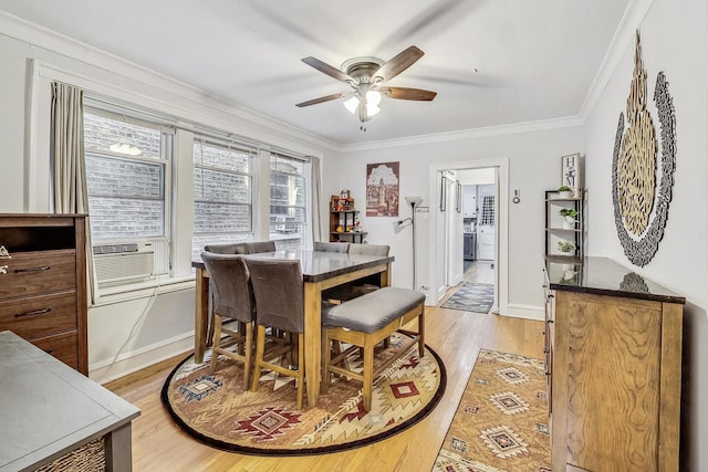 dining space featuring cooling unit, baseboards, light wood-style flooring, ceiling fan, and crown molding