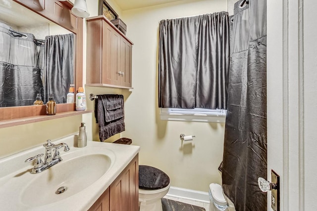 bathroom with curtained shower, baseboards, toilet, and vanity