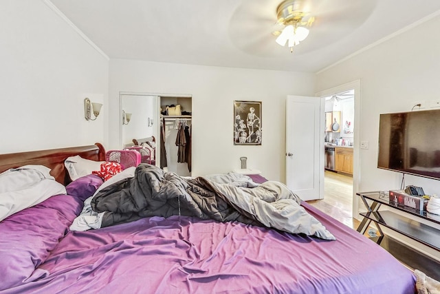 bedroom with a closet, ceiling fan, crown molding, and light wood-style floors