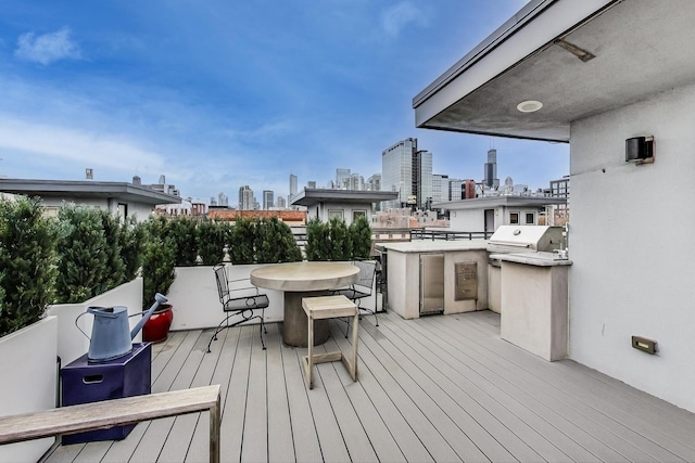 wooden terrace with a city view, area for grilling, and outdoor dining area