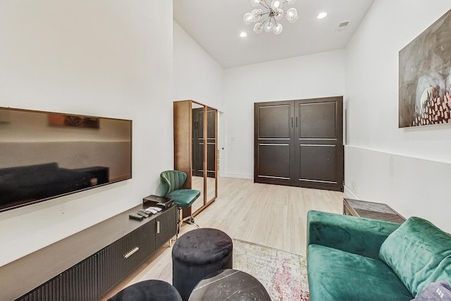 living room with visible vents, baseboards, light wood-style flooring, recessed lighting, and a notable chandelier