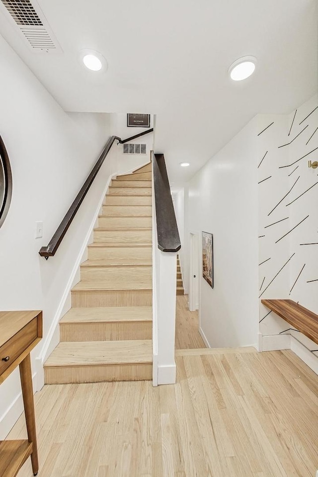 staircase featuring visible vents, recessed lighting, and wood finished floors