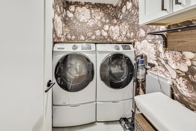 washroom with cabinet space and washer and clothes dryer