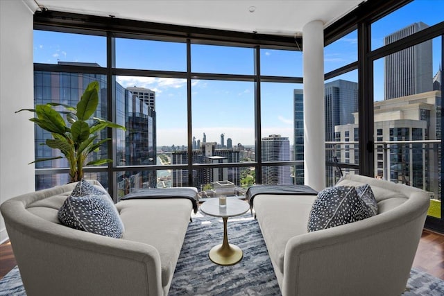 living area featuring a city view, wood finished floors, and floor to ceiling windows