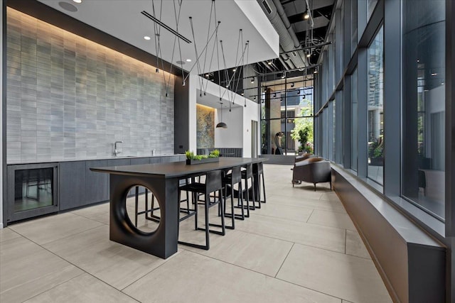 interior space with light tile patterned flooring and a towering ceiling