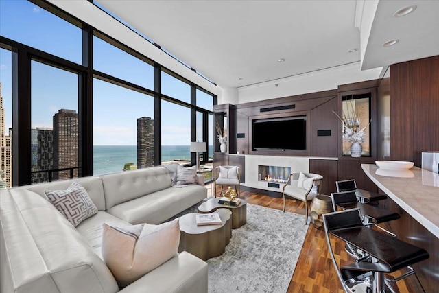 living room with a premium fireplace, recessed lighting, wood walls, and wood finished floors