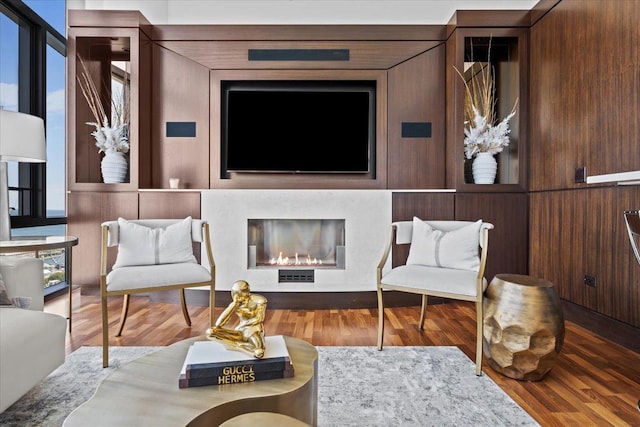 living area featuring a glass covered fireplace and wood finished floors