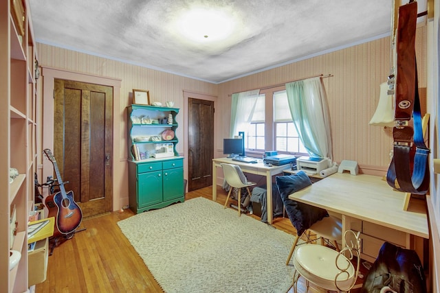 office area featuring light wood-style flooring, crown molding, and wallpapered walls