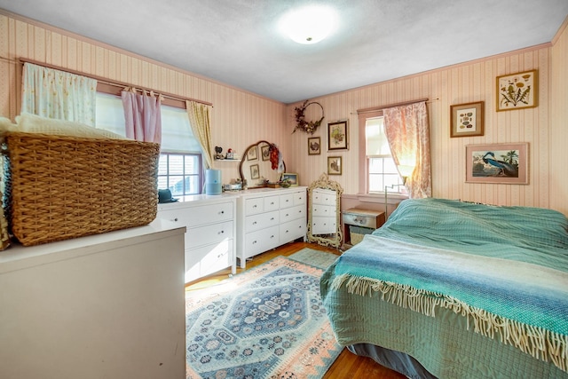 bedroom with wallpapered walls and wood finished floors