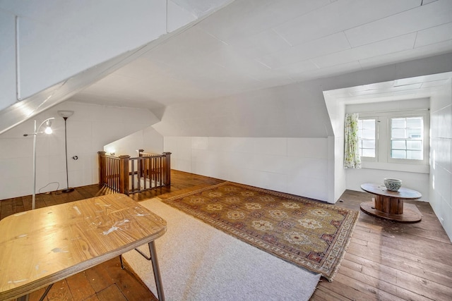 bonus room with hardwood / wood-style floors and vaulted ceiling