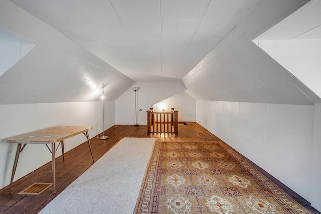 bonus room featuring visible vents, wood-type flooring, and vaulted ceiling