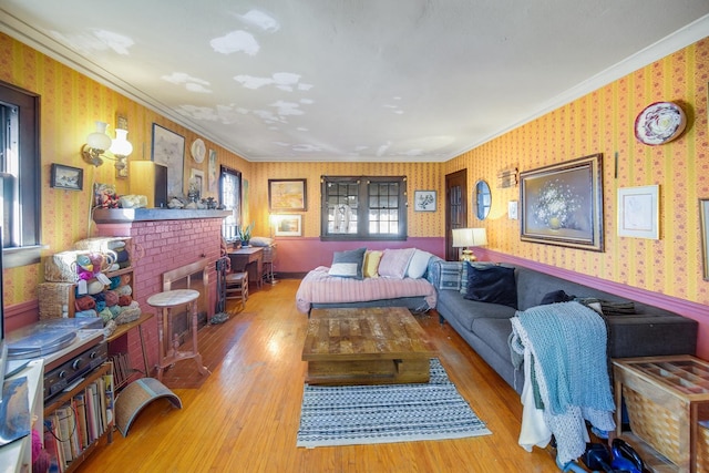 living area with wallpapered walls, crown molding, and wood finished floors