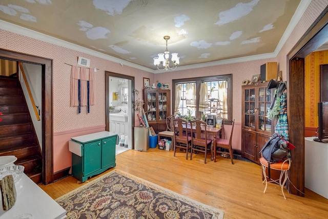 dining room with wallpapered walls, stairs, a chandelier, and ornamental molding