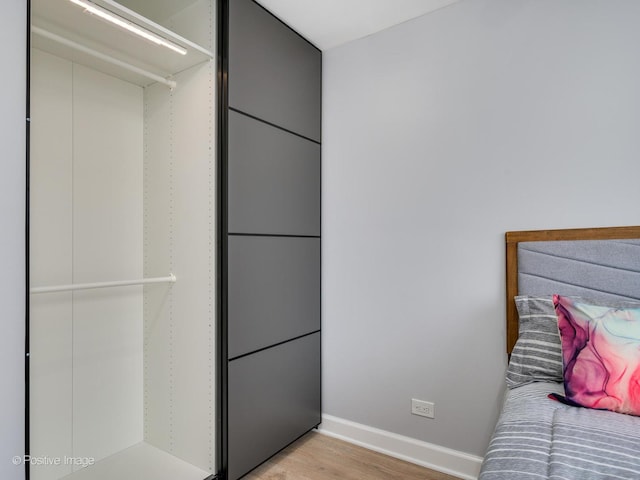 unfurnished bedroom featuring light wood-type flooring and baseboards