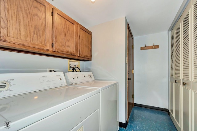 clothes washing area with washer and dryer, cabinet space, and baseboards