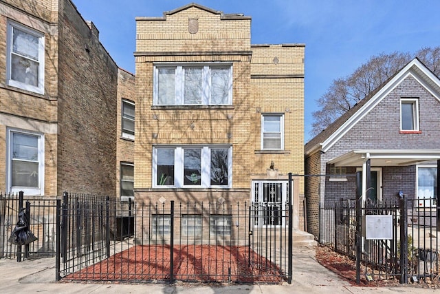 view of front of house featuring a fenced front yard, brick siding, and a gate