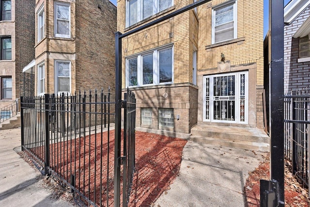 property entrance with brick siding and fence