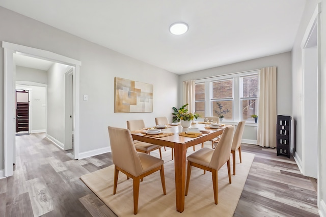 dining area featuring stairway, baseboards, and light wood-style floors