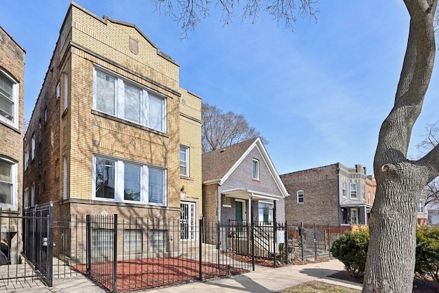 view of front of property featuring brick siding and a fenced front yard