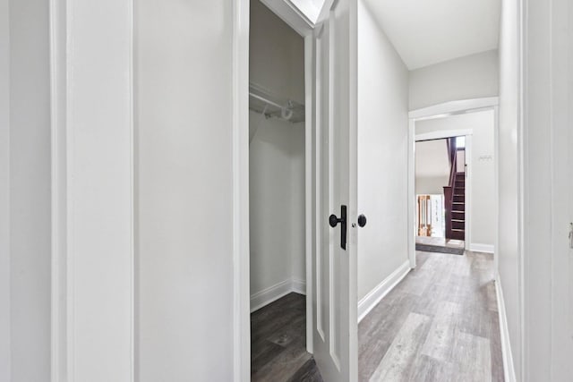 hallway with baseboards and wood finished floors