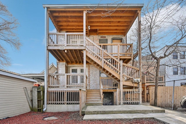 back of house featuring stairs, fence, and a wooden deck