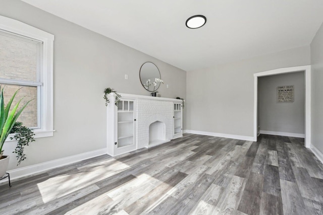 unfurnished living room featuring baseboards and wood finished floors