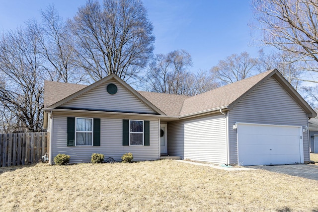 ranch-style house with fence, an attached garage, a shingled roof, a front lawn, and aphalt driveway