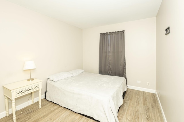 bedroom with wood finished floors and baseboards