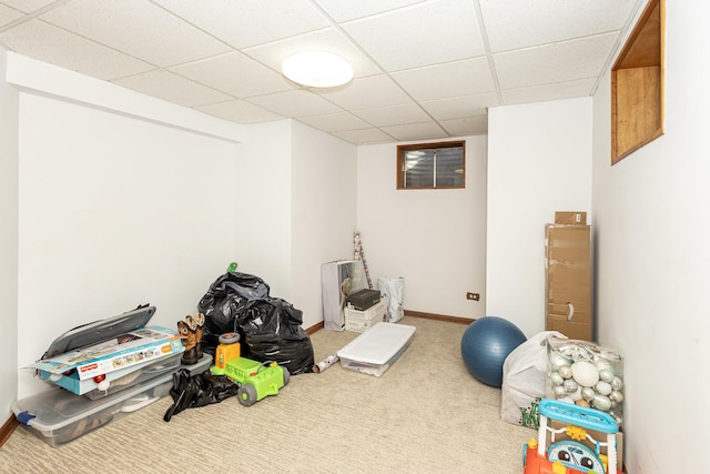 interior space with a paneled ceiling, baseboards, and carpet floors