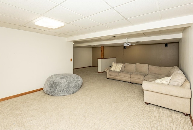 living room featuring a paneled ceiling, baseboards, and carpet floors