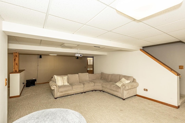 carpeted living room with baseboards and a paneled ceiling